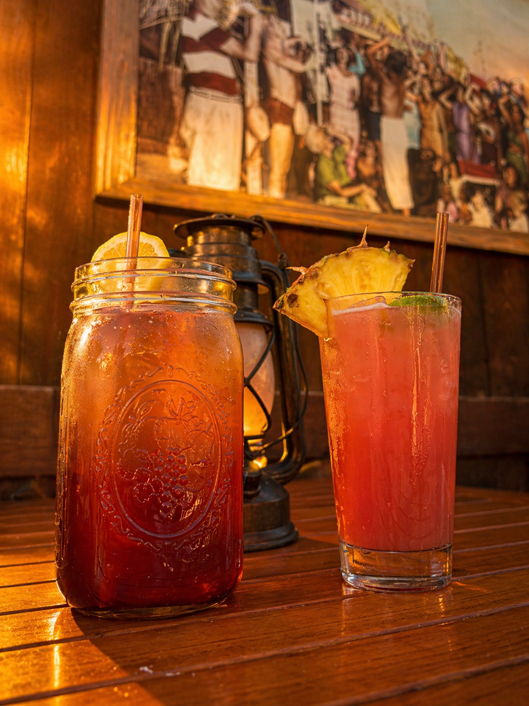 Two colorful pineapple-garnished cocktails inside the Bootlegger Bar.