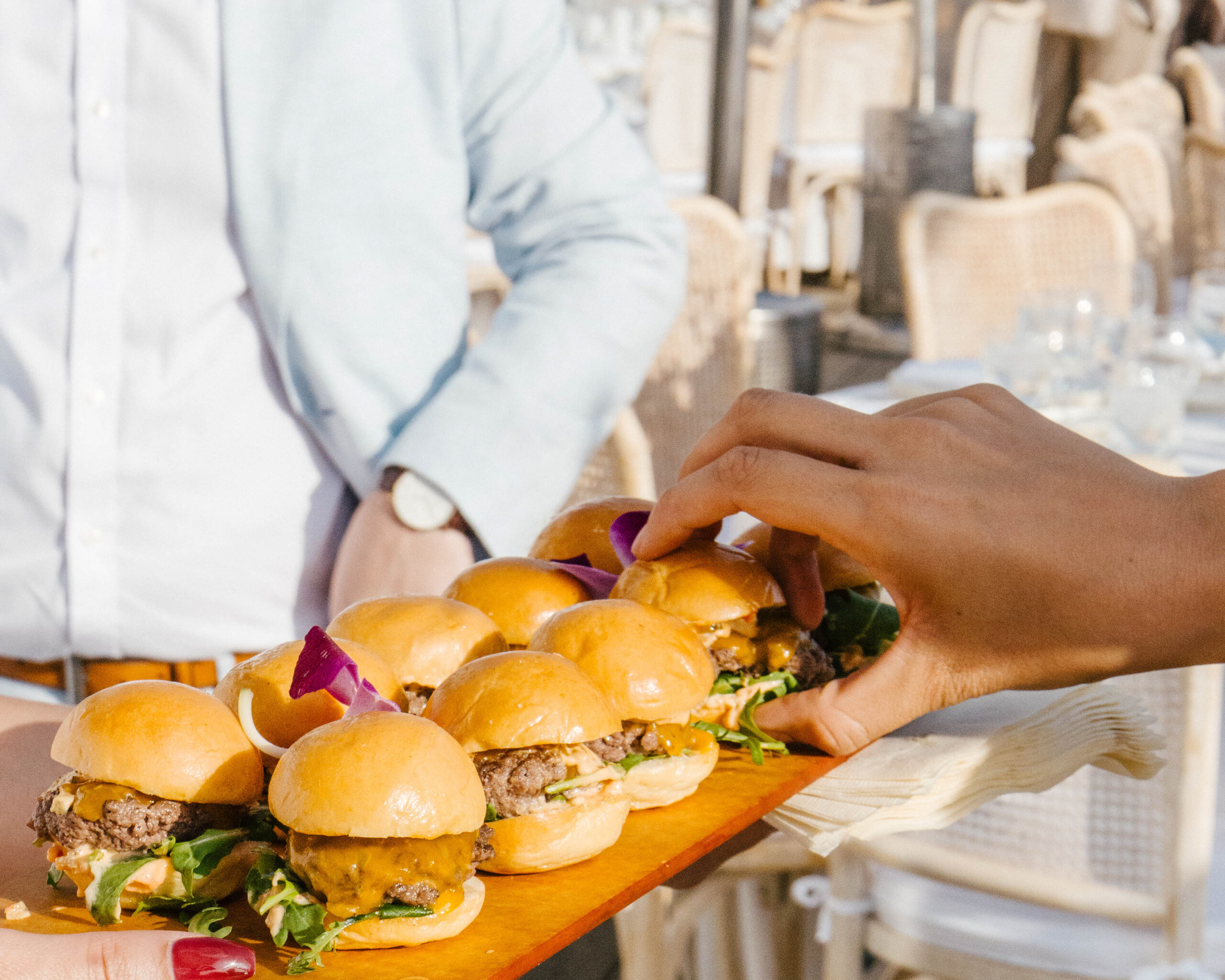Golden-bun sliders served on a wooden board.