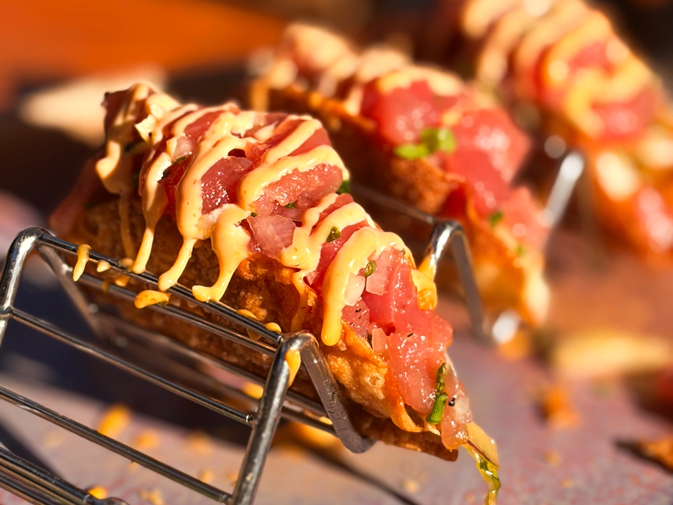 Tiny ahi tacos with colorful tuna and golden sauce.