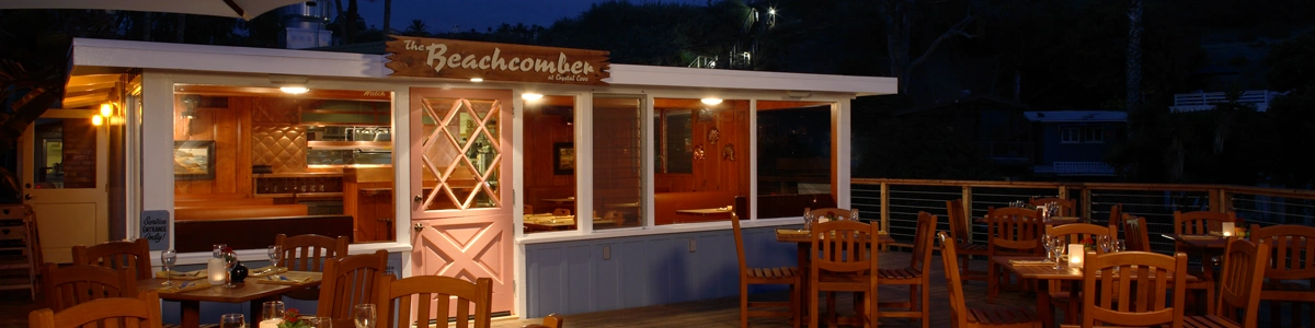The Beachcomber dining room and patio glowing with warm lights at night.