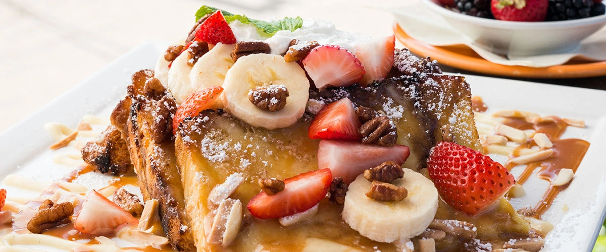 French toast topped with strawberries, banana and pecans.